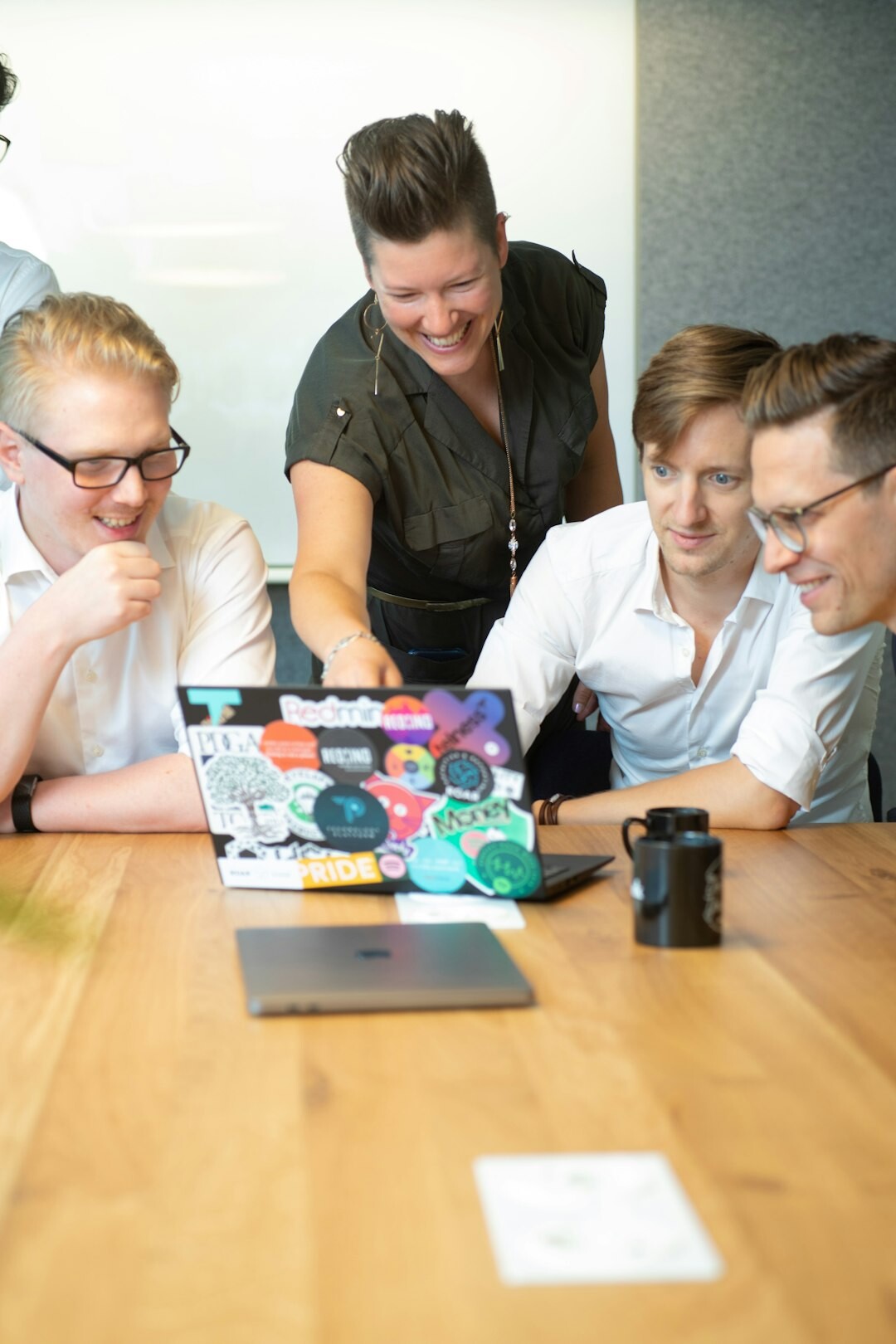 Small team gathered around a table planning an activity with a tablet