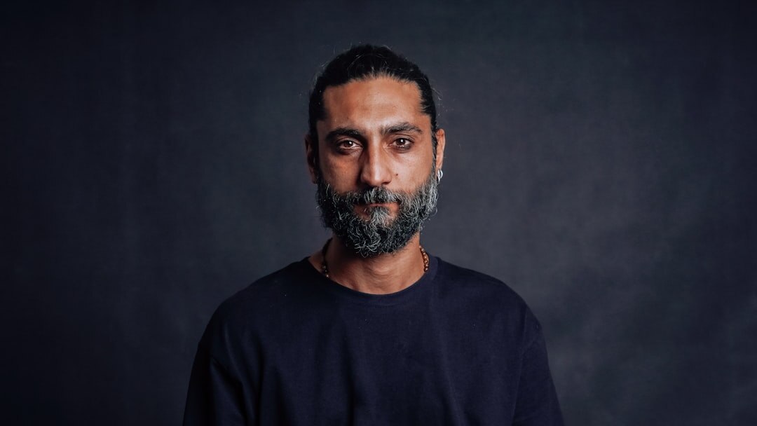 Studio portrait of a Middle Eastern man in his 30s, workshop facilitator